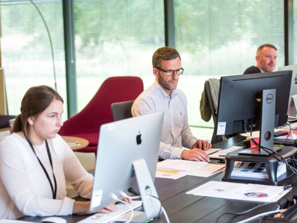 Grupo de personas trabajando con sus equipos informáticos
