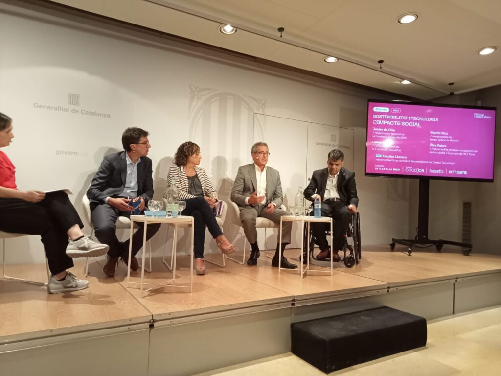 Panel de expertos discutiendo sobre sostenibilidad, tecnología e impacto social en un evento de la Generalitat de Catalunya, con una pantalla al fondo que muestra detalles de la jornada.