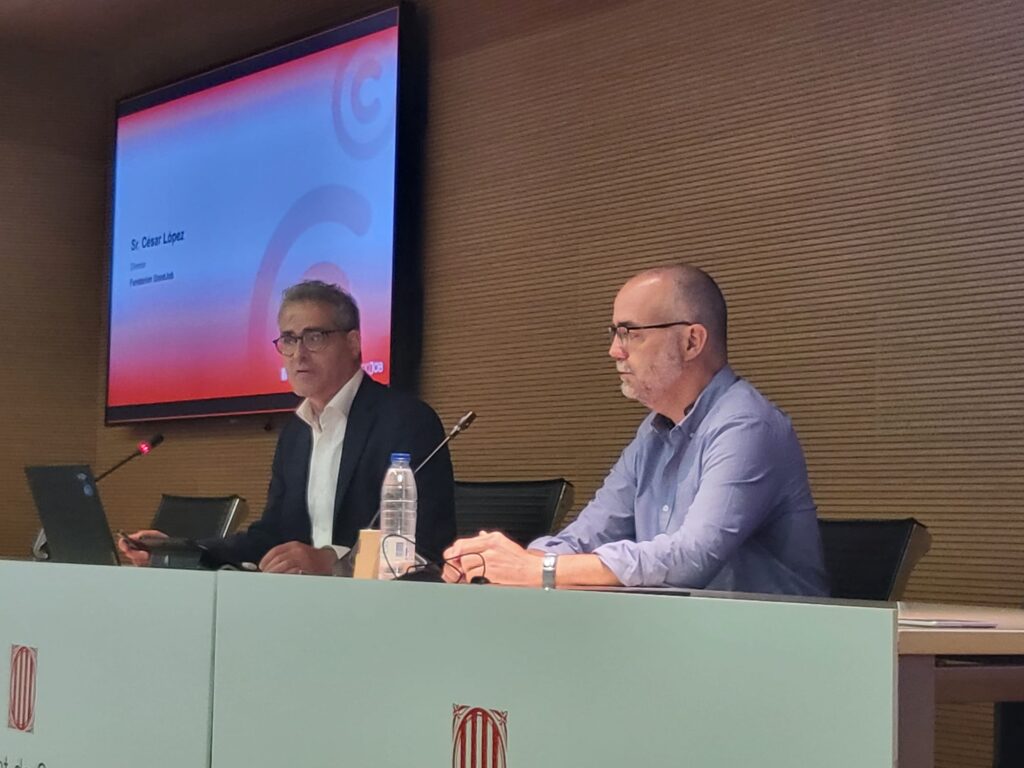 Sr. César López y otro orador participando en una conferencia de Fundación GoodJob, con una presentación en pantalla.